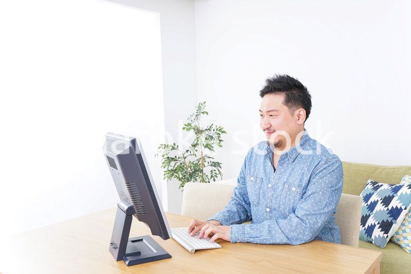 家でパソコンを使う男性