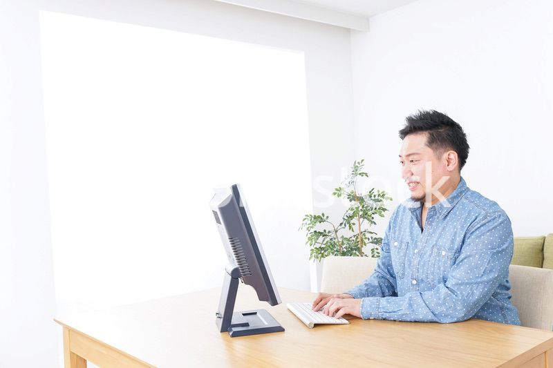 家でパソコンを使う男性