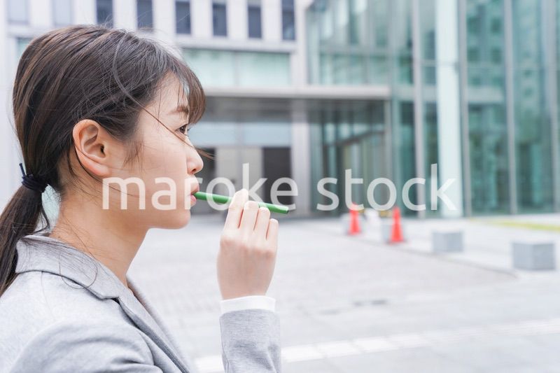 電子タバコを吸う若いビジネスウーマン