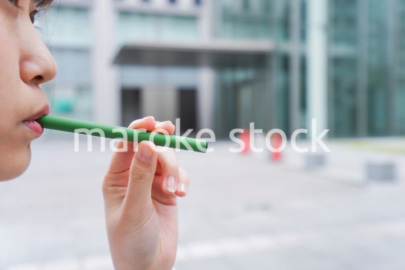 電子タバコを吸う若いビジネスウーマン