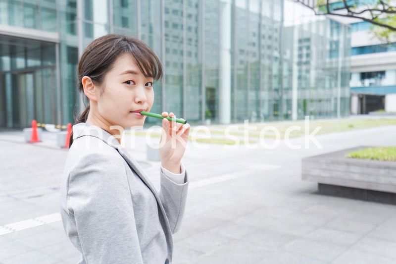 電子タバコを吸う若いビジネスウーマン