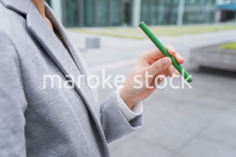 電子タバコを吸う若いビジネスウーマン