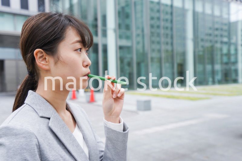 電子タバコを吸う若いビジネスウーマン