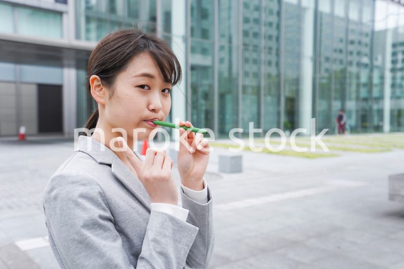 電子タバコを吸う若いビジネスウーマン