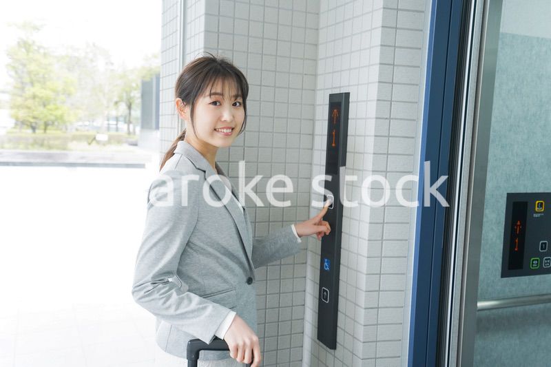 エレベーターを使う若いビジネスウーマン