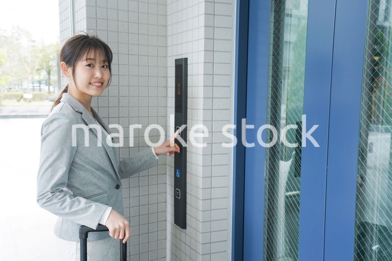 エレベーターを使う若いビジネスウーマン