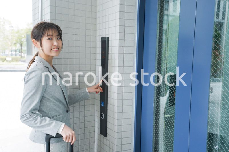 エレベーターを使う若いビジネスウーマン