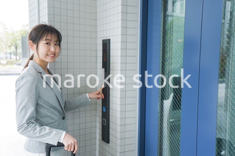 エレベーターを使う若いビジネスウーマン