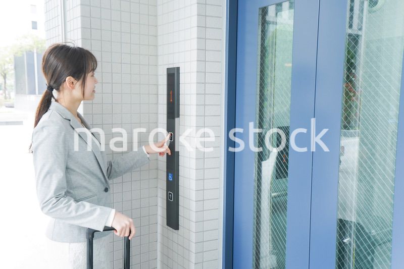 エレベーターを使う若いビジネスウーマン
