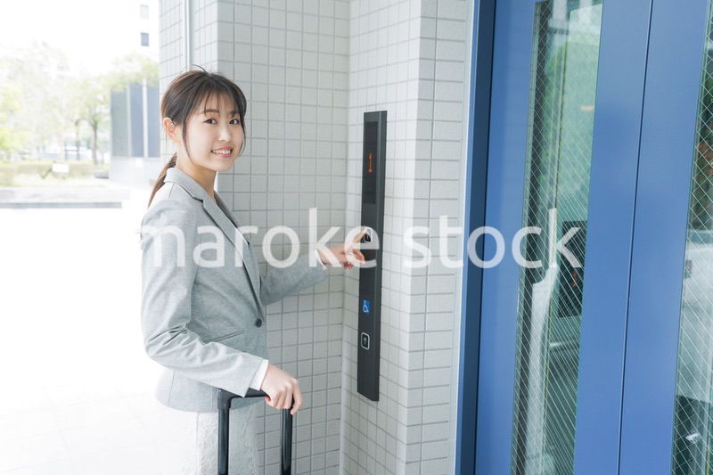 エレベーターを使う若いビジネスウーマン