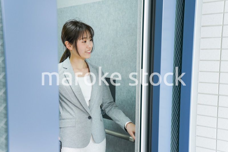 エレベーターを使う若いビジネスウーマン