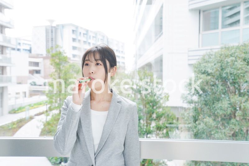 電子タバコを吸う若いビジネスウーマン