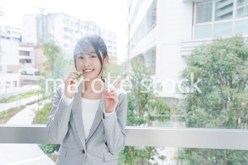 電子タバコを吸う若いビジネスウーマン