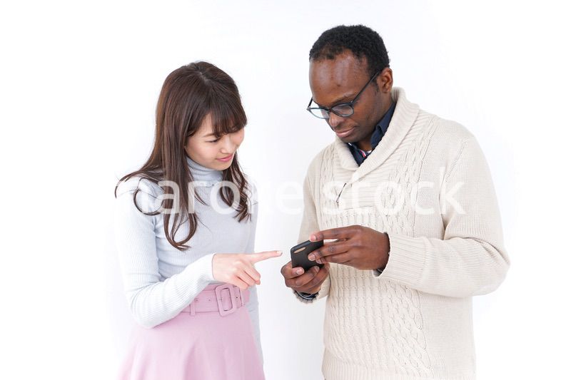 外国人観光客に道案内をする若い女性