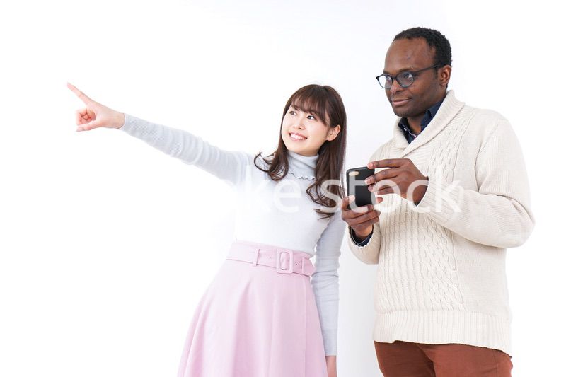 外国人観光客に道案内をする若い女性