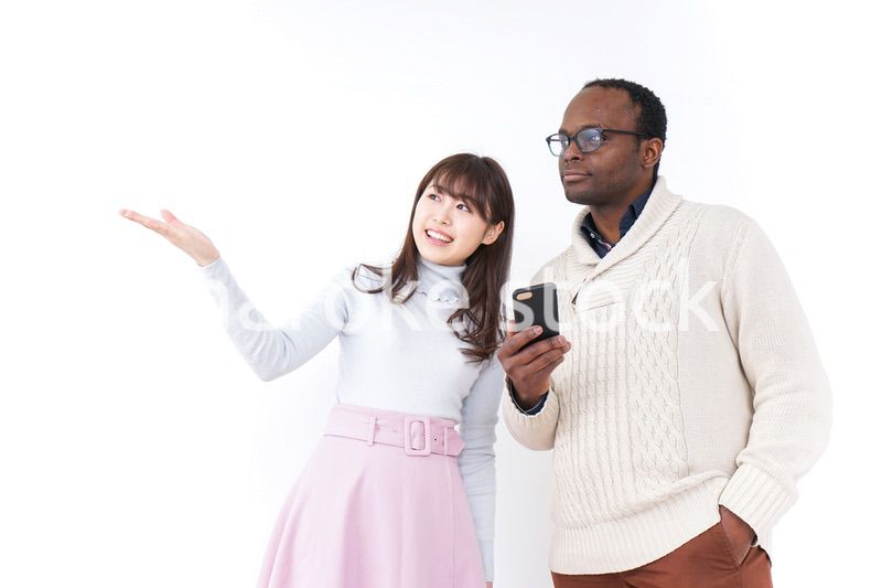 外国人観光客に道案内をする若い女性