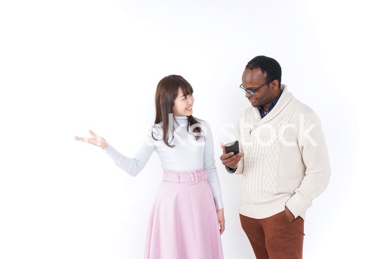 外国人観光客に道案内をする若い女性