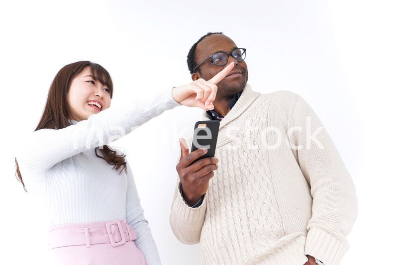 外国人観光客に道案内をする若い女性