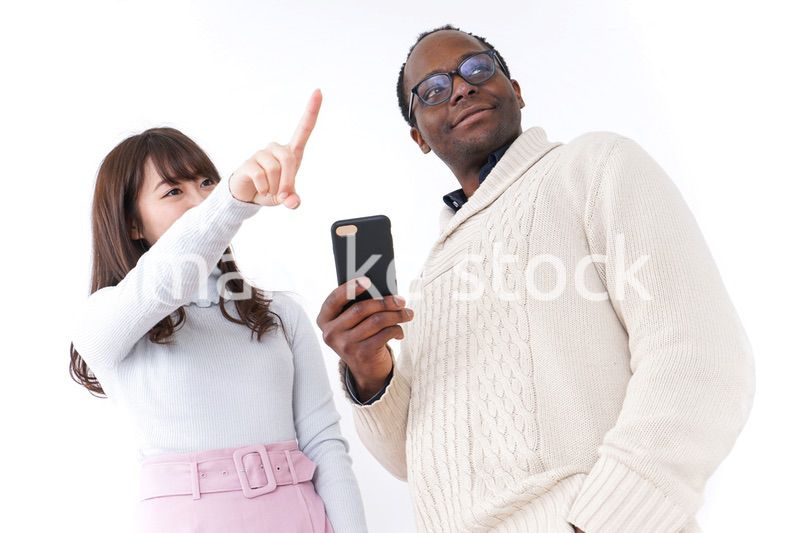 外国人観光客に道案内をする若い女性