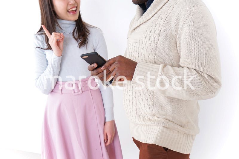 外国人観光客に道案内をする若い女性