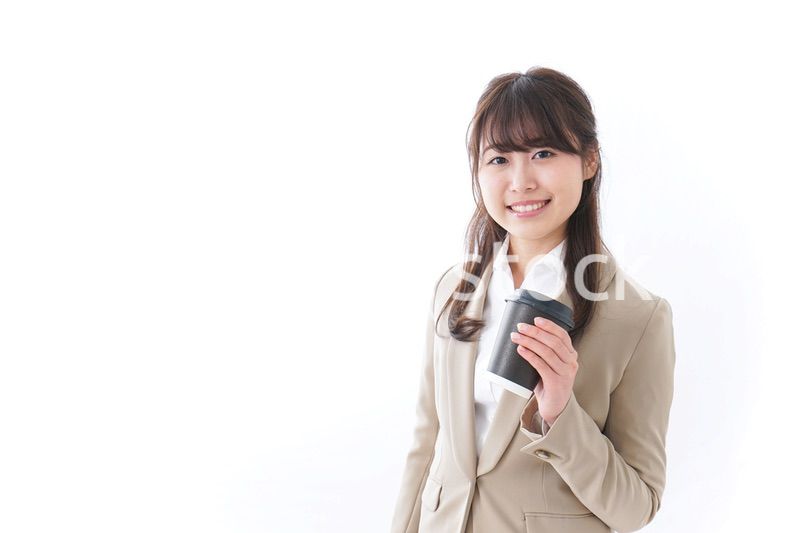 コンビニでコーヒーを買うビジネスウーマン