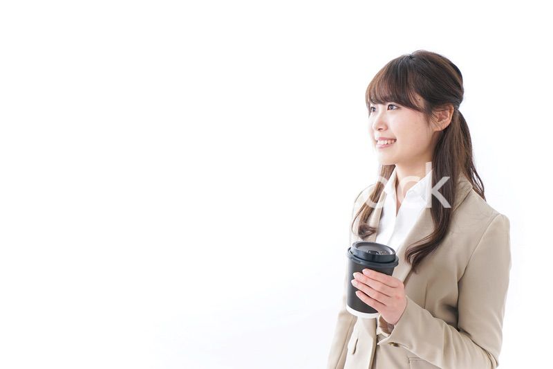 コンビニでコーヒーを買うビジネスウーマン