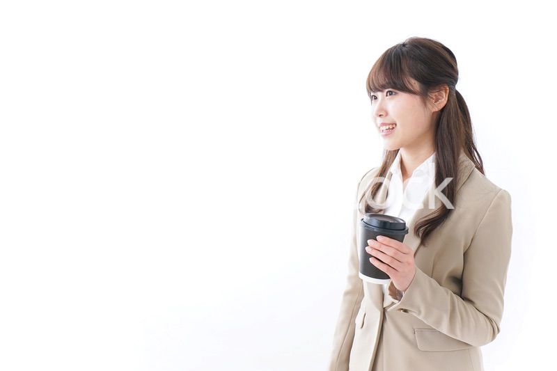 コンビニでコーヒーを買うビジネスウーマン