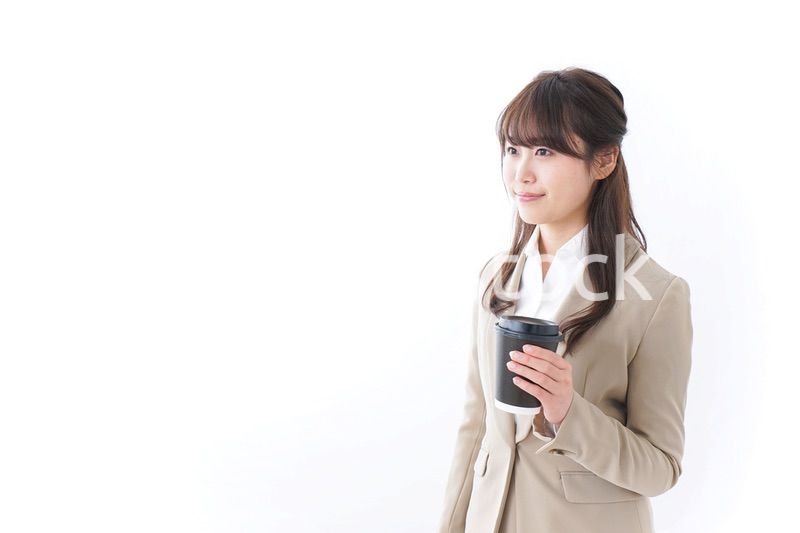 コンビニでコーヒーを買うビジネスウーマン