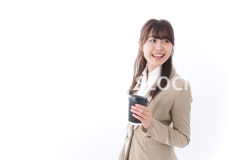 コンビニでコーヒーを買うビジネスウーマン