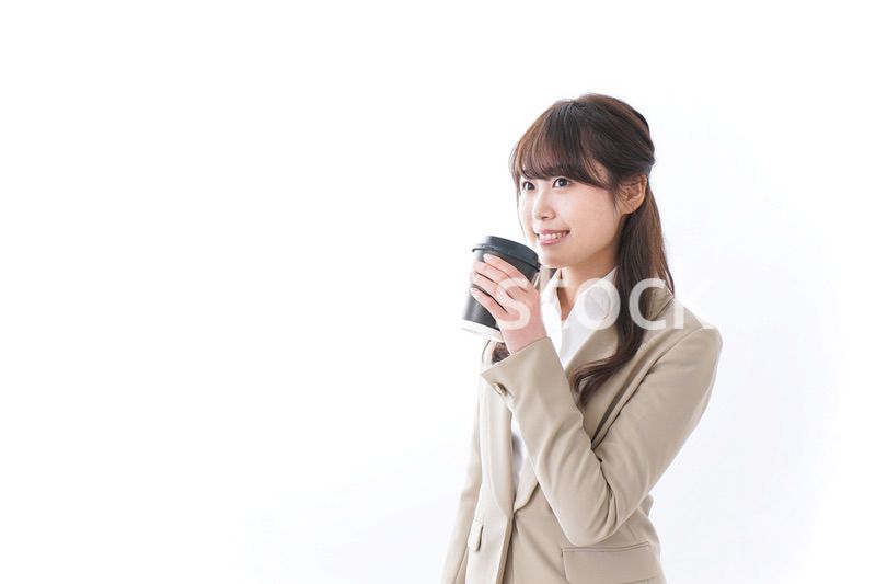 コンビニでコーヒーを買うビジネスウーマン
