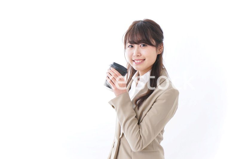 コンビニでコーヒーを買うビジネスウーマン