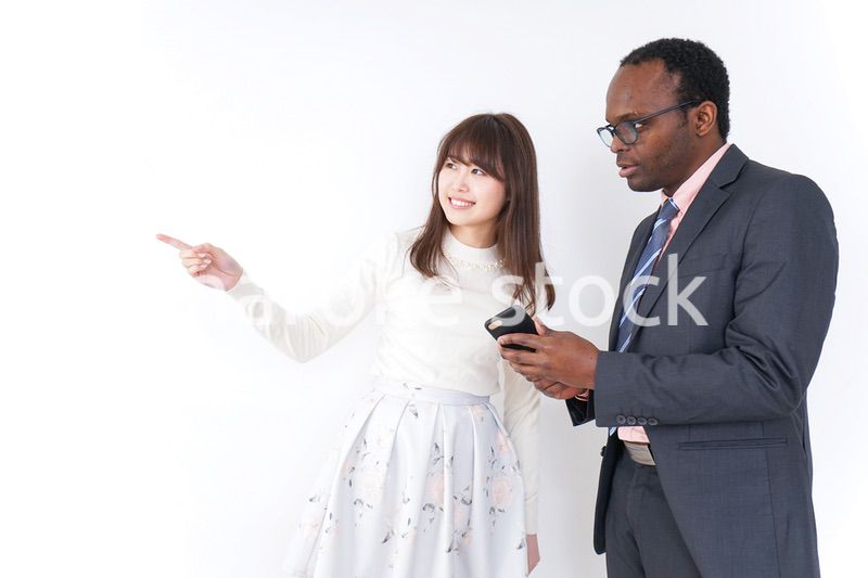 外国人に道案内をする若い女性