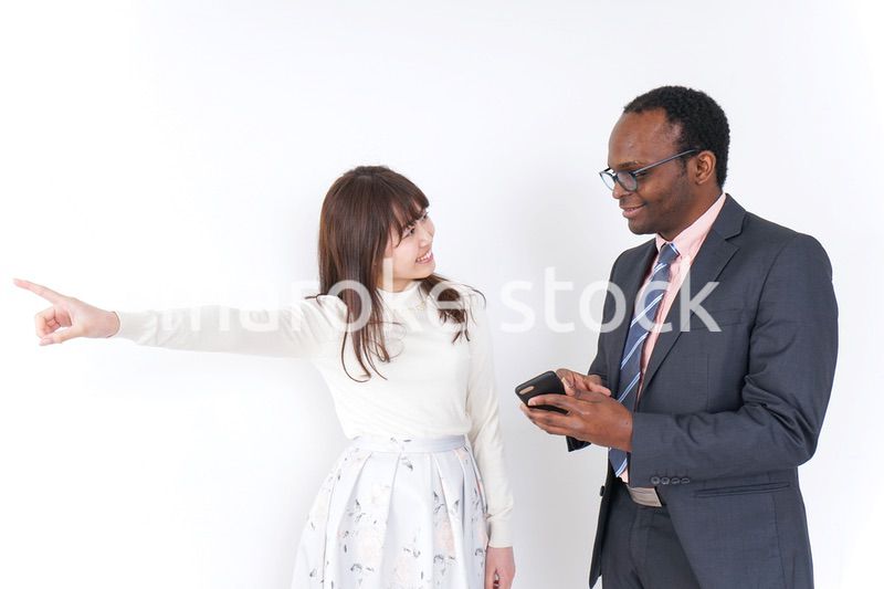 外国人に道案内をする若い女性