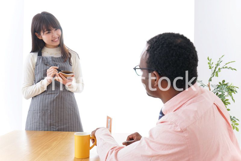 外国人に接客をするカフェスタッフ