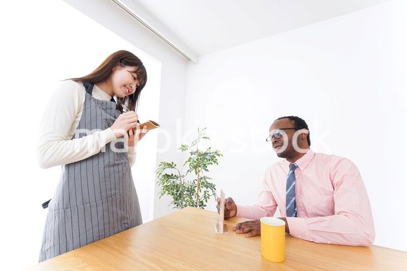 外国人に接客をするカフェスタッフ