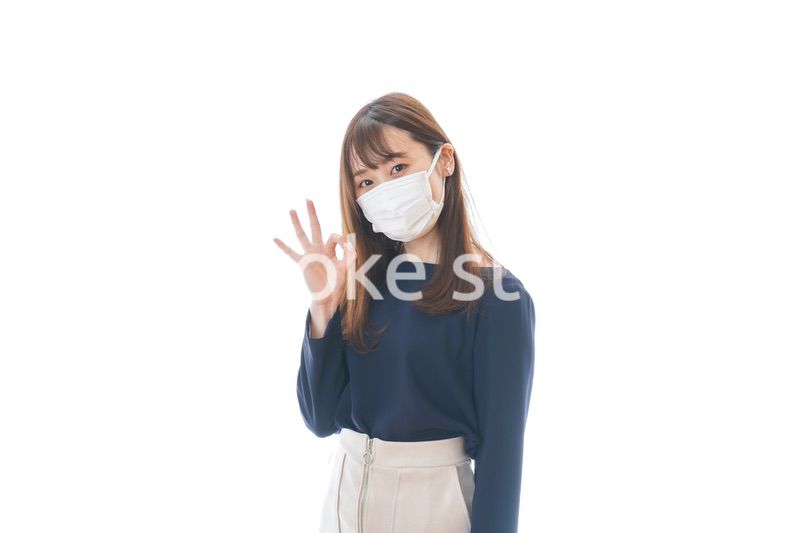 マスクを装着してOKサインをする若い女性