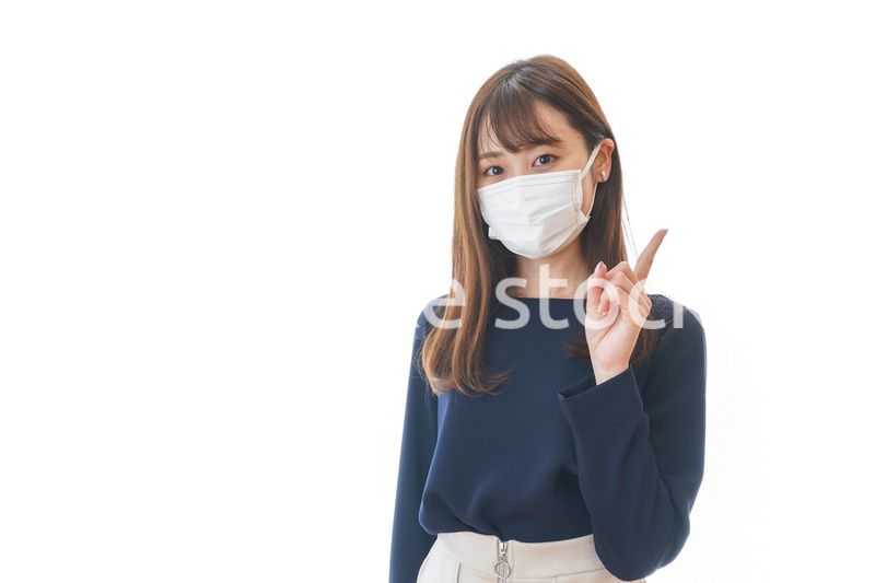 マスクを装着して指を指す若い女性