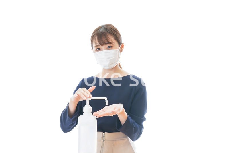 手のアルコール消毒をする若い女性