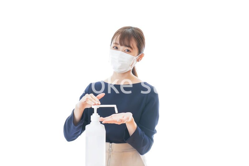 手のアルコール消毒をする若い女性