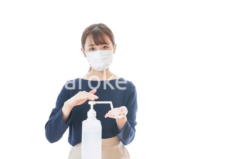 手のアルコール消毒をする若い女性