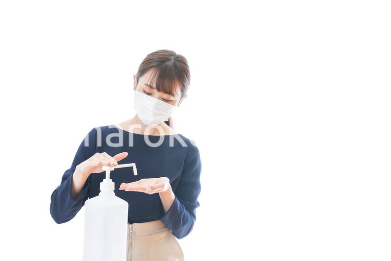 手のアルコール消毒をする若い女性