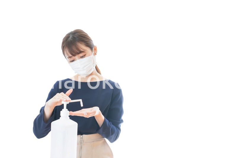 手のアルコール消毒をする若い女性