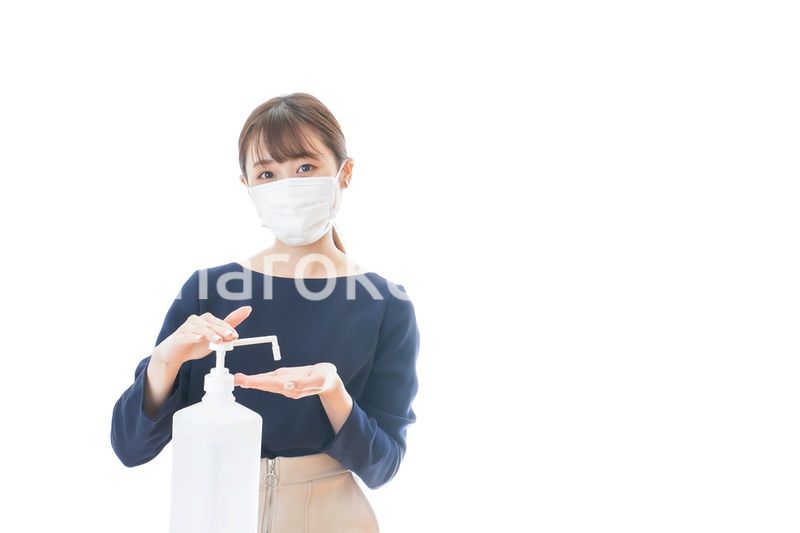 手のアルコール消毒をする若い女性