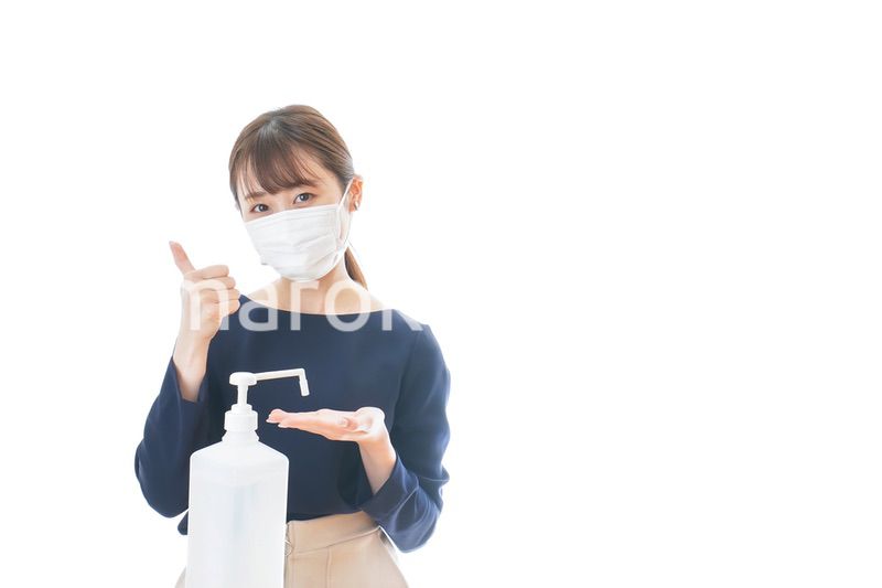 OKサインをしながらアルコール消毒をする若い女性