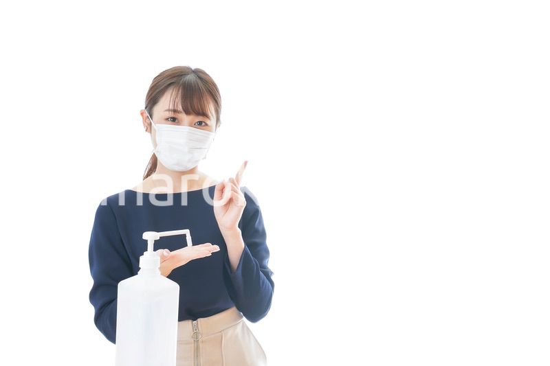 OKサインをしながらアルコール消毒をする若い女性