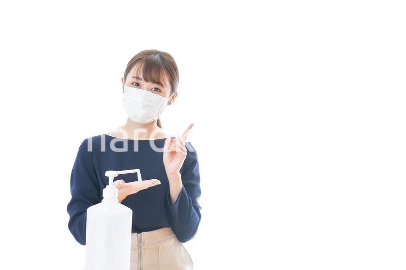 OKサインをしながらアルコール消毒をする若い女性