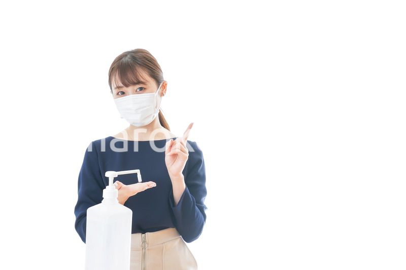 OKサインをしながらアルコール消毒をする若い女性
