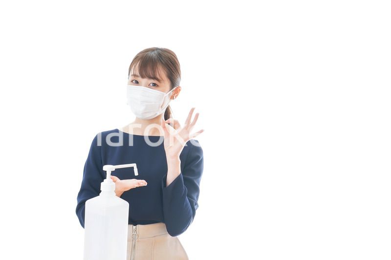 マスクを装着してOKサインをする若い女性