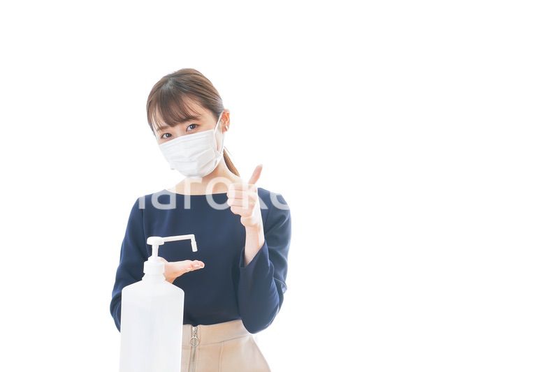 OKサインをしながらアルコール消毒をする若い女性