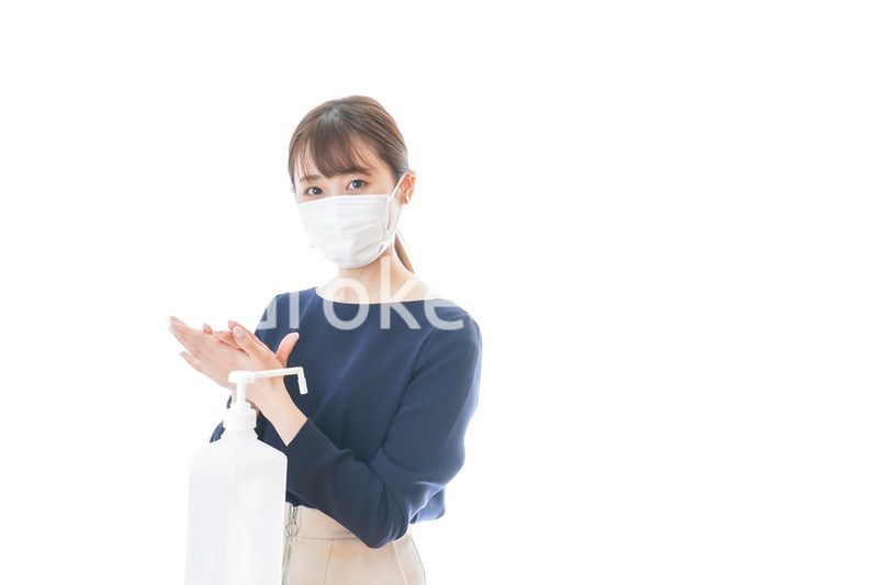 手のアルコール消毒をする若い女性